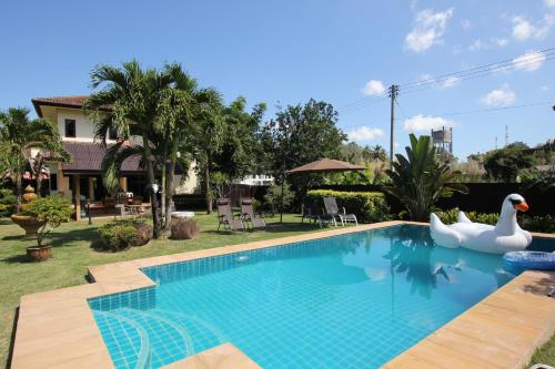 - une piscine avec deux cygnes dans la cour dans l'établissement Bann Jai Dee, à Nai Yang Beach