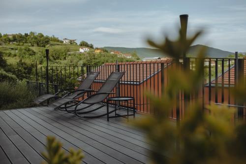 a group of chairs sitting on a wooden deck at Glamping Senesalina in Kojsko