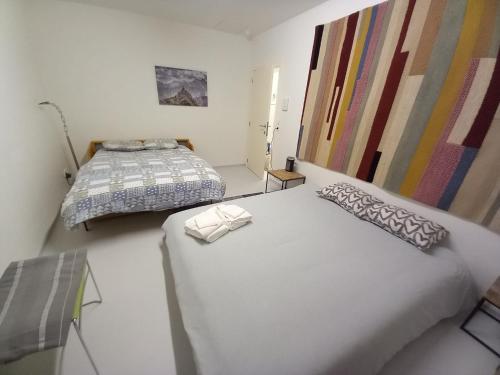 a bedroom with two beds and paintings on the wall at Chez Jean-Claude Chambre 4 personnes in Wavre