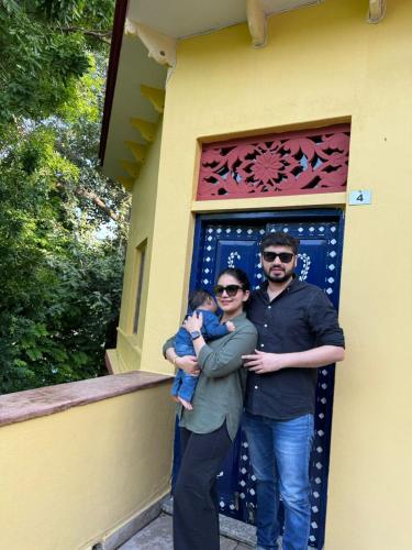 a man and a woman holding a baby in front of a building at Gopagiri Homestay - Gwalior in Gwalior