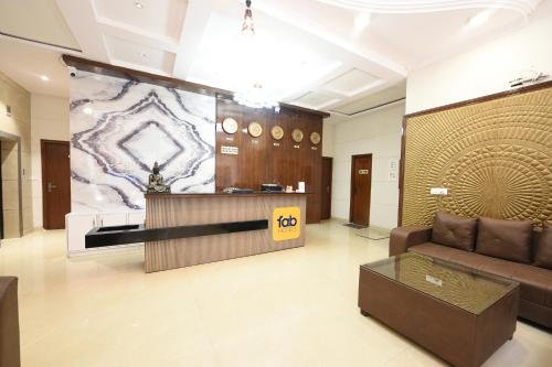 a lobby with a couch and a reception desk at FabHotel Alpine Tree in Amritsar