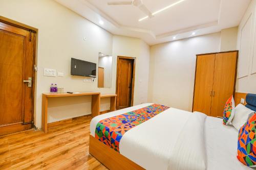 a bedroom with a bed and a desk and a television at FabHotel Alpine Tree in Amritsar