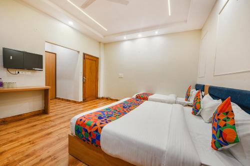 a hotel room with a bed and a television at FabHotel Alpine Tree in Amritsar