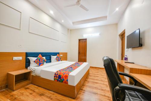a bedroom with a bed and a desk and a television at FabHotel Alpine Tree in Amritsar