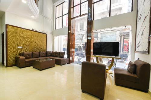 a living room with couches and a flat screen tv at FabHotel Alpine Tree in Amritsar