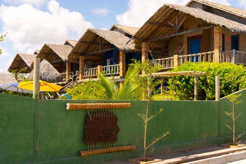 a house with a green fence in front of it at Pousada Nascer da Lua in Fortim