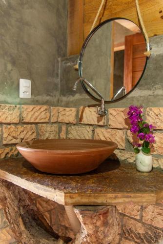 a brown bowl on a stone counter with a mirror at Pousada Nascer da Lua in Fortim