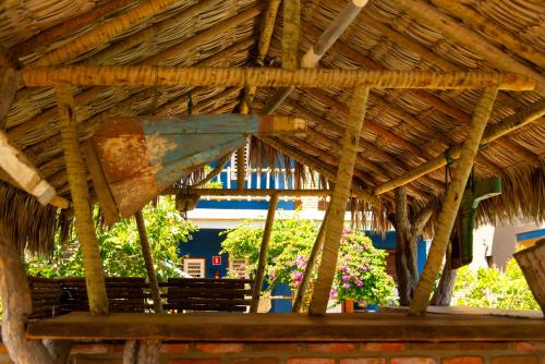 a wooden bench under a thatched roof at Pousada Nascer da Lua in Fortim