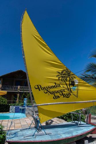 a yellow sail on a boat on the beach at Pousada Nascer da Lua in Fortim
