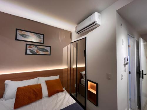 um quarto com uma cama e um ar condicionado na parede em Studio moderno e charmoso no melhor lugar da Barra em Salvador