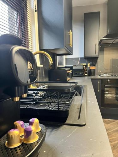 a kitchen with a stove with cupcakes on a tray at CENTRAL SERVICED APARTMENTS - 2 Double Bedrooms - Monifieth - Sleeps 4 - Modern & Unique - Smart TV & WiFi - Fully Equipped Kitchen - Spacious & Unique in Monifieth
