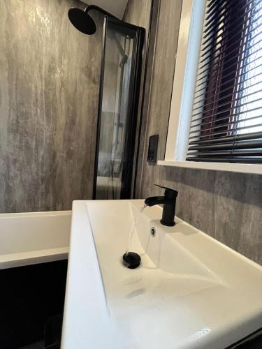 a bathroom sink with a faucet on top of it at CENTRAL SERVICED APARTMENTS - 2 Double Bedrooms - Monifieth - Sleeps 4 - Modern & Unique - Smart TV & WiFi - Fully Equipped Kitchen - Spacious & Unique in Monifieth