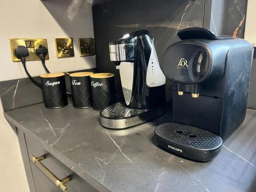 a counter with a coffeemaker and a coffee maker at CENTRAL SERVICED APARTMENTS - 2 Double Bedrooms - Monifieth - Sleeps 4 - Modern & Unique - Smart TV & WiFi - Fully Equipped Kitchen - Spacious & Unique in Monifieth