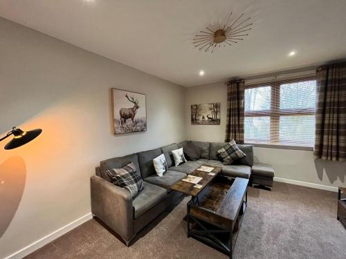 a living room with a couch and a table at CENTRAL SERVICED APARTMENTS - 2 Double Bedrooms - Monifieth - Sleeps 4 - Modern & Unique - Smart TV & WiFi - Fully Equipped Kitchen - Spacious & Unique in Monifieth