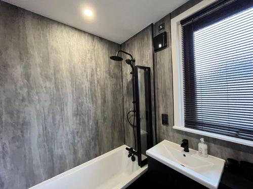 a bathroom with a sink and a bath tub at CENTRAL SERVICED APARTMENTS - 2 Double Bedrooms - Monifieth - Sleeps 4 - Modern & Unique - Smart TV & WiFi - Fully Equipped Kitchen - Spacious & Unique in Monifieth