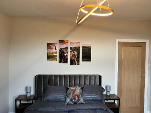 a bedroom with four pictures on the wall at CENTRAL SERVICED APARTMENTS - 2 Double Bedrooms - Monifieth - Sleeps 4 - Modern & Unique - Smart TV & WiFi - Fully Equipped Kitchen - Spacious & Unique in Monifieth