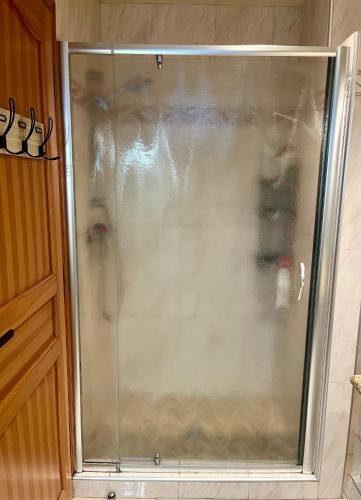 - une douche en verre dans la salle de bains avec une personne dans l'établissement Villa Victoire au coeur de la Provence, à Venelles