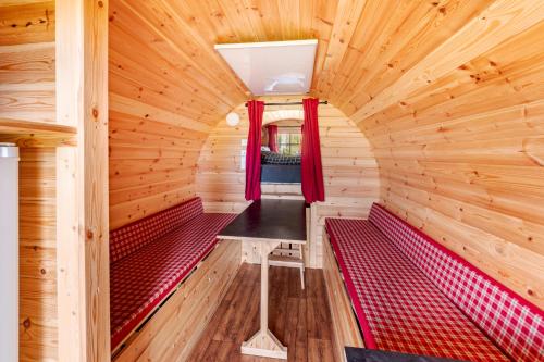 a room with red benches in a wooden cabin at Camping u Kukačků in Horní Planá