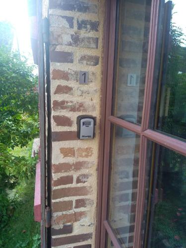 une horloge sur un mur de briques à côté d'une fenêtre dans l'établissement une maison à la campagne, à Fruncé