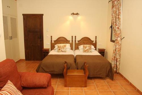El Hoyo的住宿－Cortijo El Criadero，一间卧室配有一张床和一张沙发