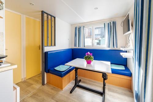 a room with a table and a blue bench at Camping u Kukačků in Horní Planá