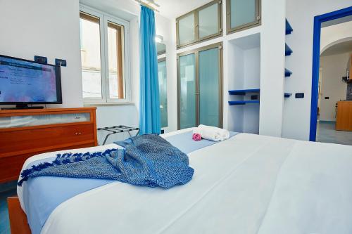 a bedroom with a white bed with a tv on it at Appartamenti Rosa Dei Venti in Trapani
