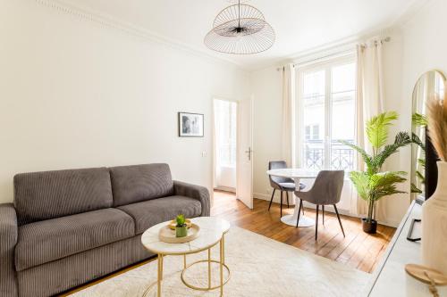 un salon avec un canapé et une table dans l'établissement Superbe appartement Montmartre, à Paris