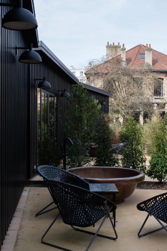 a patio with two chairs and a large tub at Hôtel Lilybloom in Le Havre