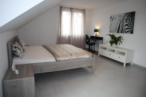 Un dormitorio con una cama y un escritorio y una ventana. en Dream Home, en Renningen