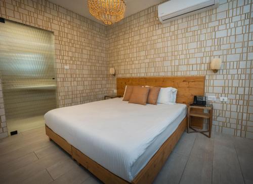 a bedroom with a large bed and a chandelier at Estate Spa Boutique Hotel - Adults Only in Rechovot