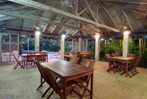 a patio with wooden tables and chairs in a building at Trinity Beach Club Holiday Apartments in Trinity Beach