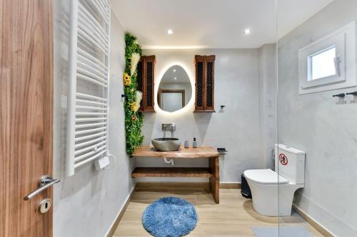 a bathroom with a sink and a toilet and a mirror at Apollon Suite in Thessaloniki