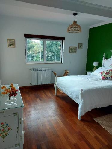 a bedroom with a white bed and a green wall at Casa Botanica in Vestiaria