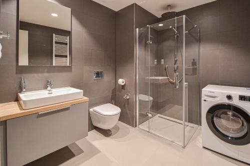 a bathroom with a shower sink and a washing machine at Japanese Design 3BDR Apartment in a Vibrant Area in Prague