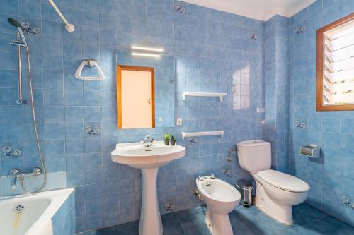 a blue tiled bathroom with a sink and a toilet at Gran Sol Family 7 in Felanitx