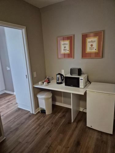 a room with a table with a microwave on it at Dolphin Beach Hotel Self Catering Apartments in Bloubergstrand