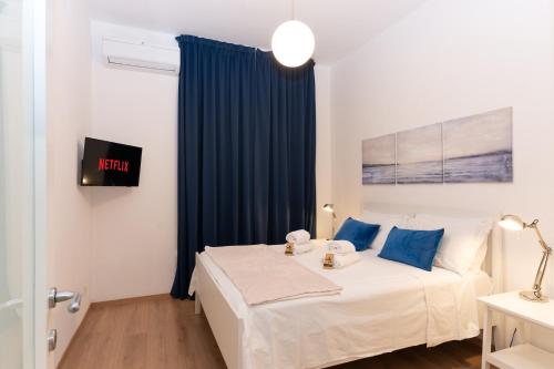 a bedroom with a bed with blue curtains at A 200m dal Mare Residenza Esclusiva in Centro con Comfort Premium, Parcheggio Pubblico a 300m in Pescara