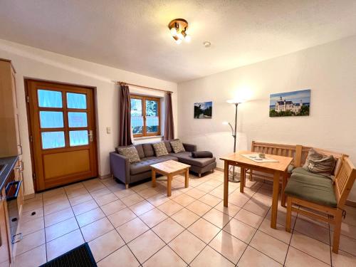a living room with a couch and a table at Appartementhaus Königstraße Ferienwohnung Hohenschwangau in Füssen