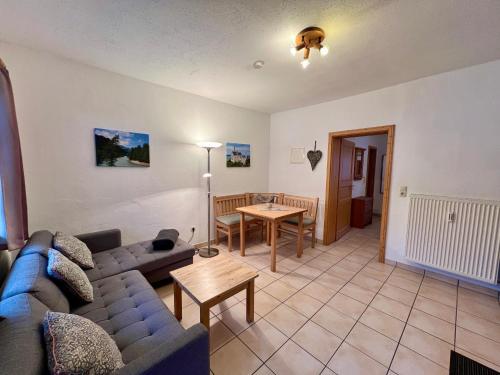 a living room with a blue couch and a table at Appartementhaus Königstraße Ferienwohnung Hohenschwangau in Füssen