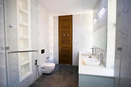 a bathroom with a toilet and a sink at Villa Santé by The Serendipity Collection in Kalpitiya