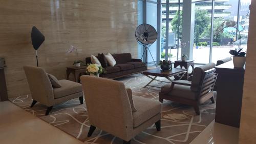 een woonkamer met een bank, stoelen en een tafel bij Signature Apartment @ The Windsor in Jakarta