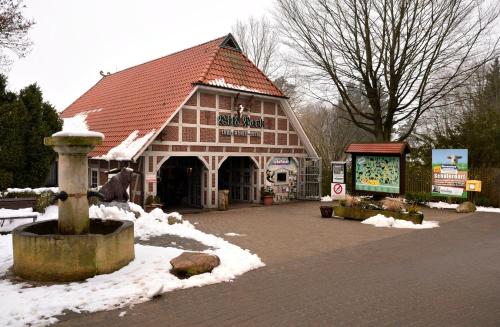 a large wooden building with snow on the ground at Hillmers Hoff PensionRestaurant in Undeloh