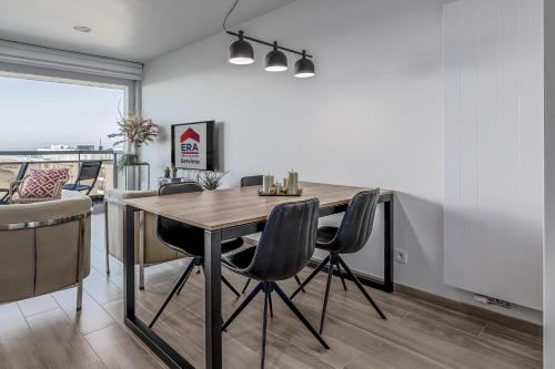 a dining room with a wooden table and chairs at Sabine 0602 G in Sint-Idesbald