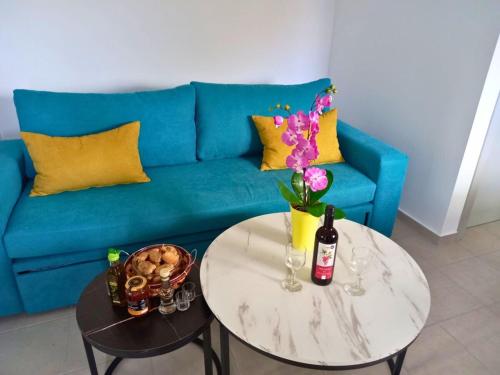 a living room with a blue couch and a table at KaVros Cozy Apartment in Kavros
