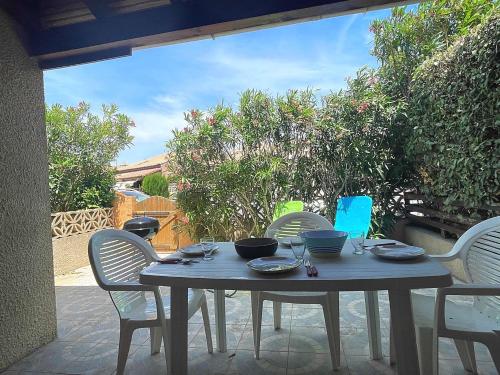 - une table avec des bols et des assiettes sur la terrasse dans l'établissement Maison studio mezzanine - Gruissan AY010-005, à Vires