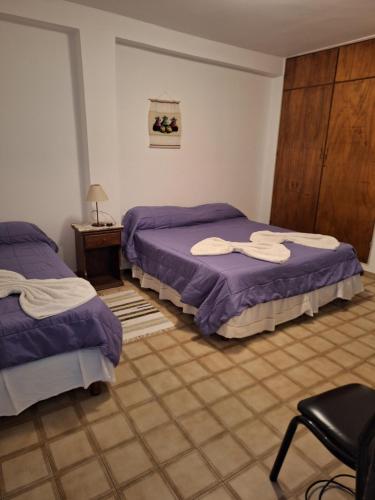 a bedroom with two beds and a table and a chair at Apartment Chunin Depart in Salta