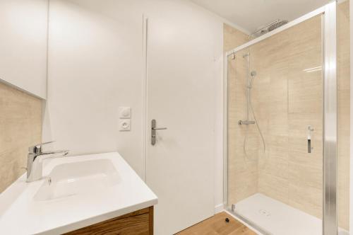 une salle de bain avec un lavabo et une douche dans l'établissement La Cité des Postiers - Joli duplex climatisé, à Toulouse