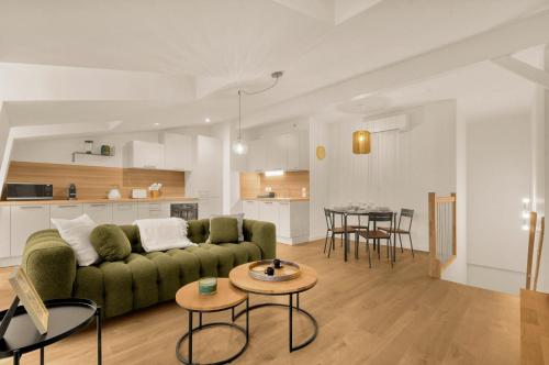 un salon avec un canapé vert et une table dans l'établissement La Cité des Postiers - Joli duplex climatisé, à Toulouse
