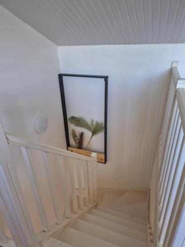 a staircase with a mirror and a picture on the wall at Maison charmante à Sainte-Anne avec jardin et pergola en bois. in Sainte-Anne