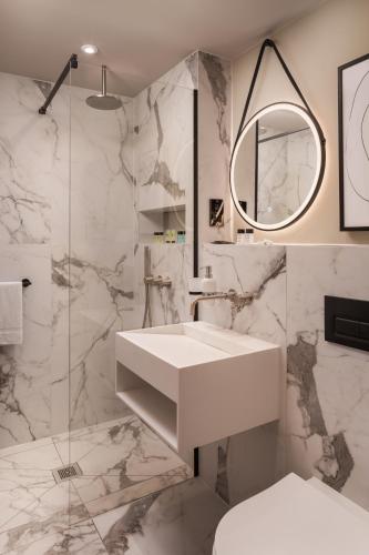 a white bathroom with a sink and a mirror at Central Park Hotel in London